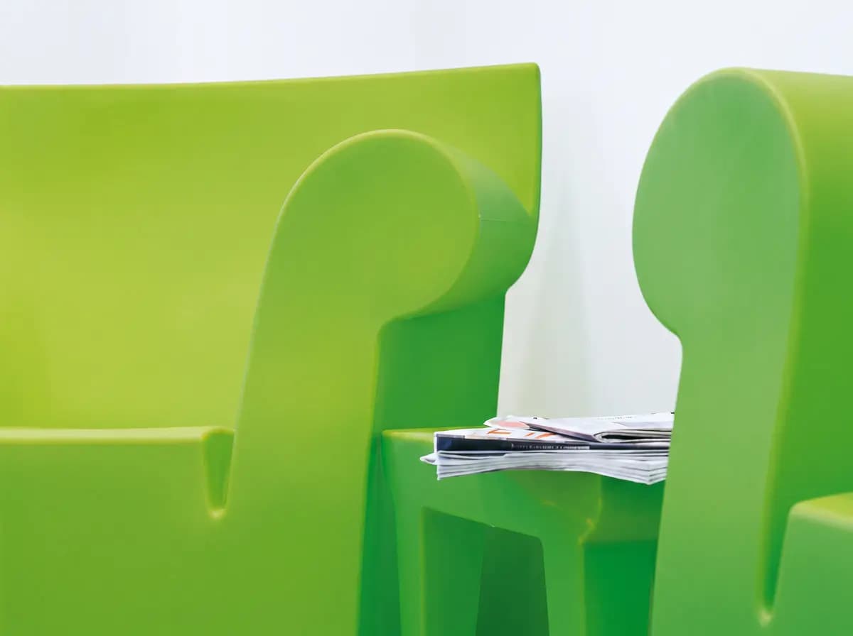 Zwei grüne Kinderstühle mit hoher Lehne im Wartebereich